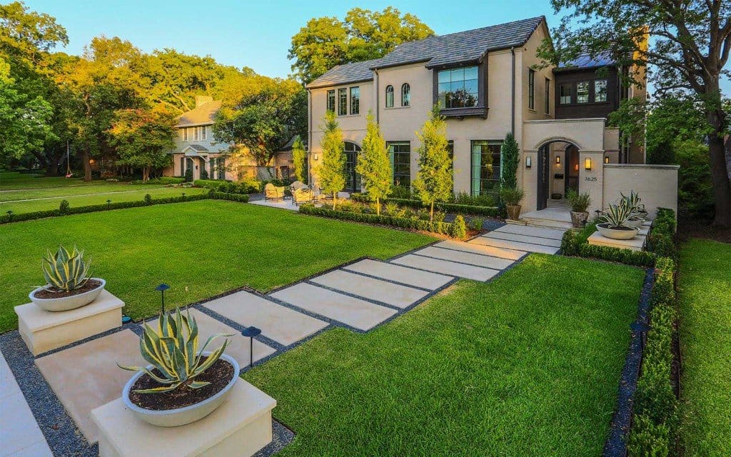 Modern home with a manicured lawn and stone walkway.