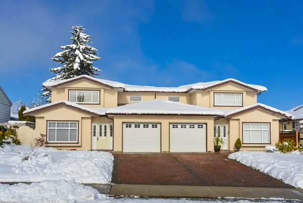 Two-story home surrounded by winter snow.