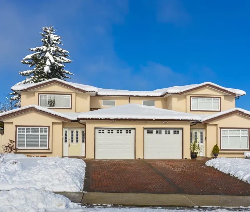 Two-story home surrounded by winter snow.