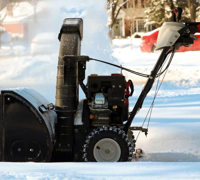 Snowblower in use on a snowy driveway
